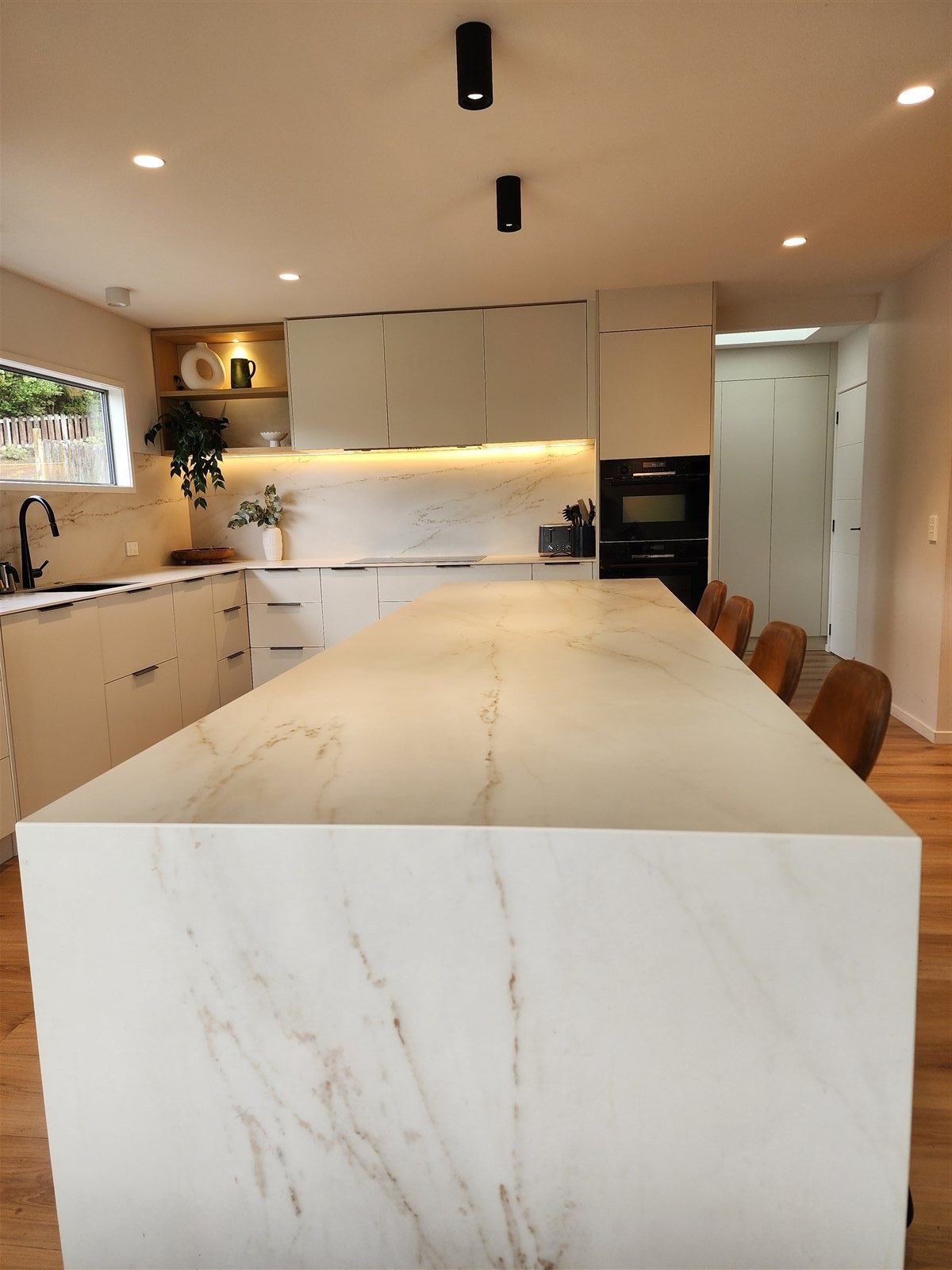 Kitchen island with built-in oven wall and stone benchtop