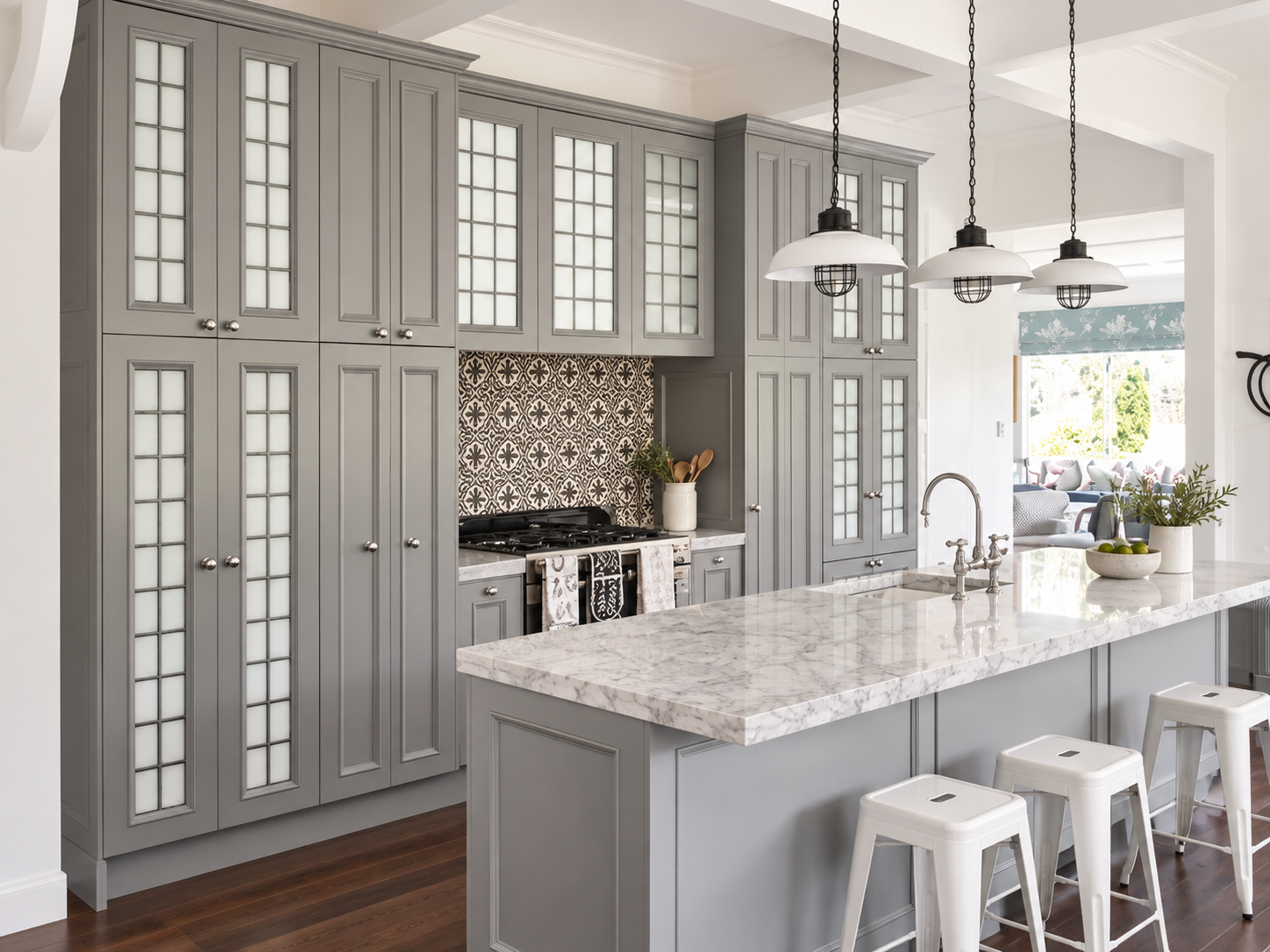 Full wall of French grey cabinetry with glass-fronted uppers, marble island and patterned splashback