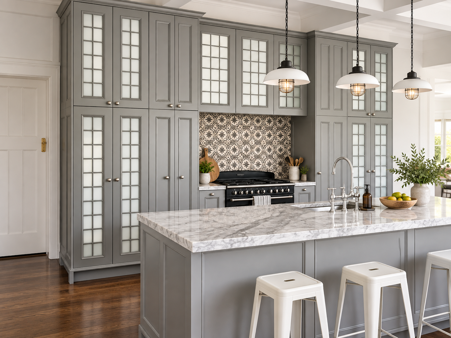 French grey kitchen showing island and floor-to-ceiling glass-front cabinetry with designer pendants
